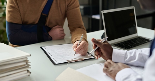 man signing documents with personal injury attorney