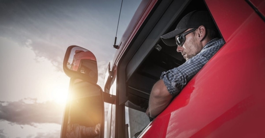 close up of a driver in a large truck looking out of the window