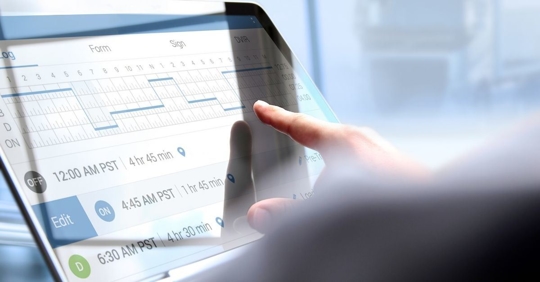 close up image of a truck driver logging their hours of service on a tablet device